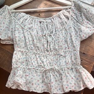 White Doen puffed sleeve blouse with floral detailing.